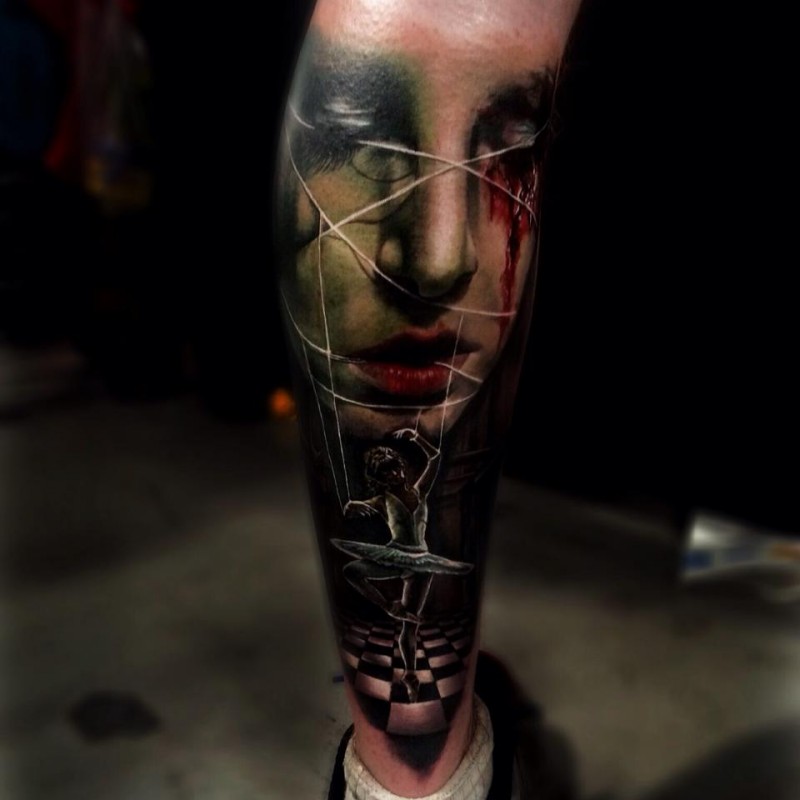 Unusual colored leg tattoo of bloody wiman face with strings and doll