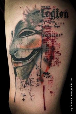 Usualmente el tatuaje de muslo coloreado de la máscara Anonimous con letras