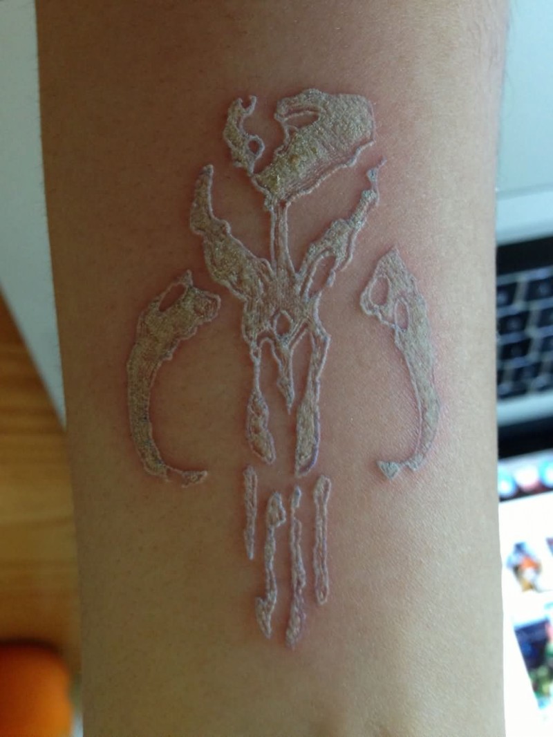 White-ink mammoth skull tattoo on arm