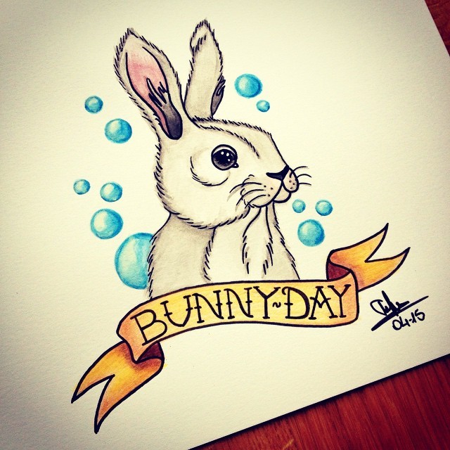 White rabbit and yellow quoted ribbon surrounded with blue bubbles tattoo design