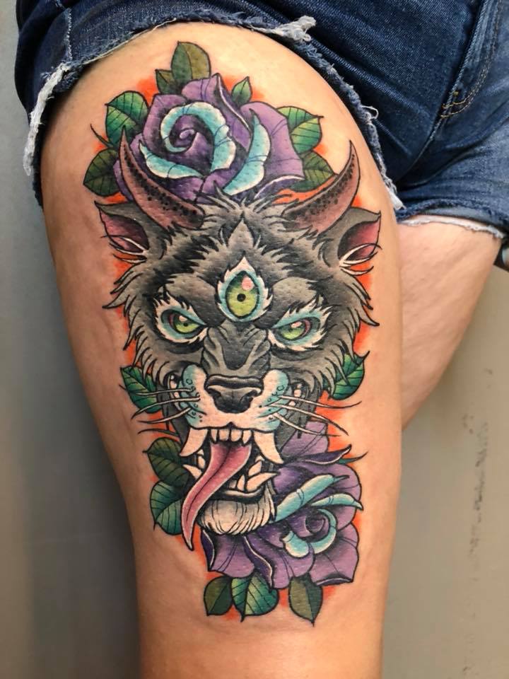 Wolf monster with three eyes and roses tattoo on thigh