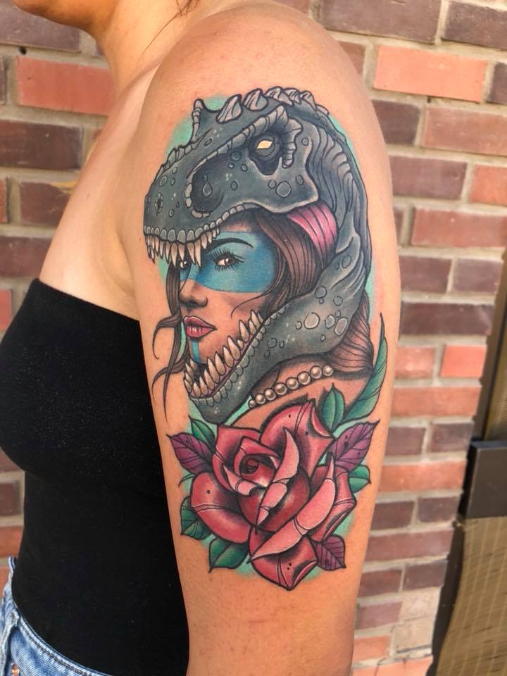 Woman in dinosaur hemlet tattoo on shoulder