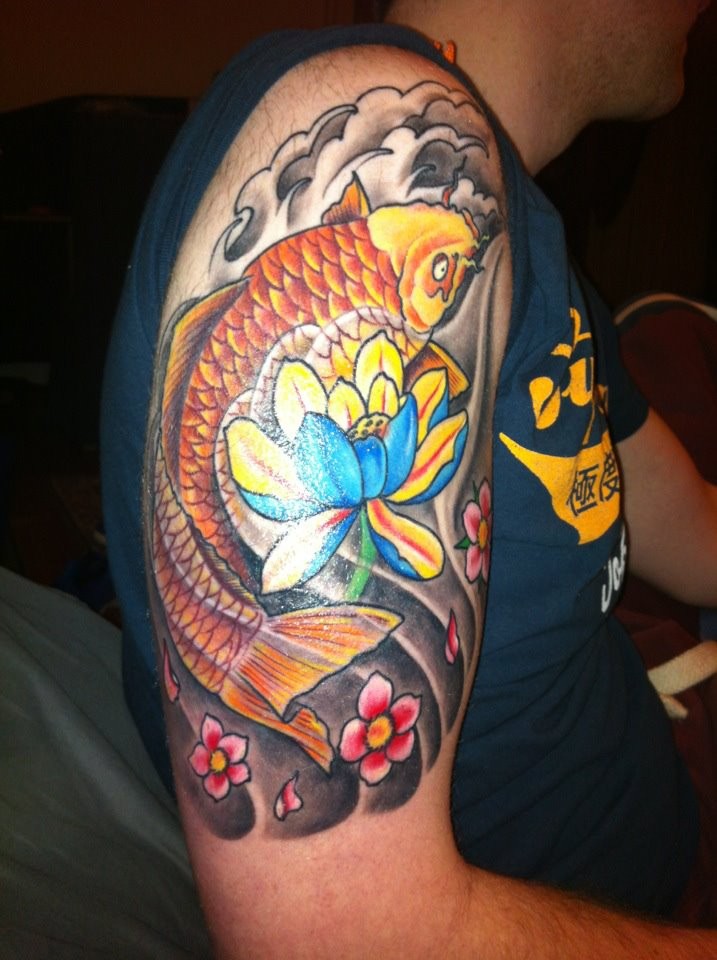 Wonderful colorful japanese flowers and golden fish tattoo on upper arm