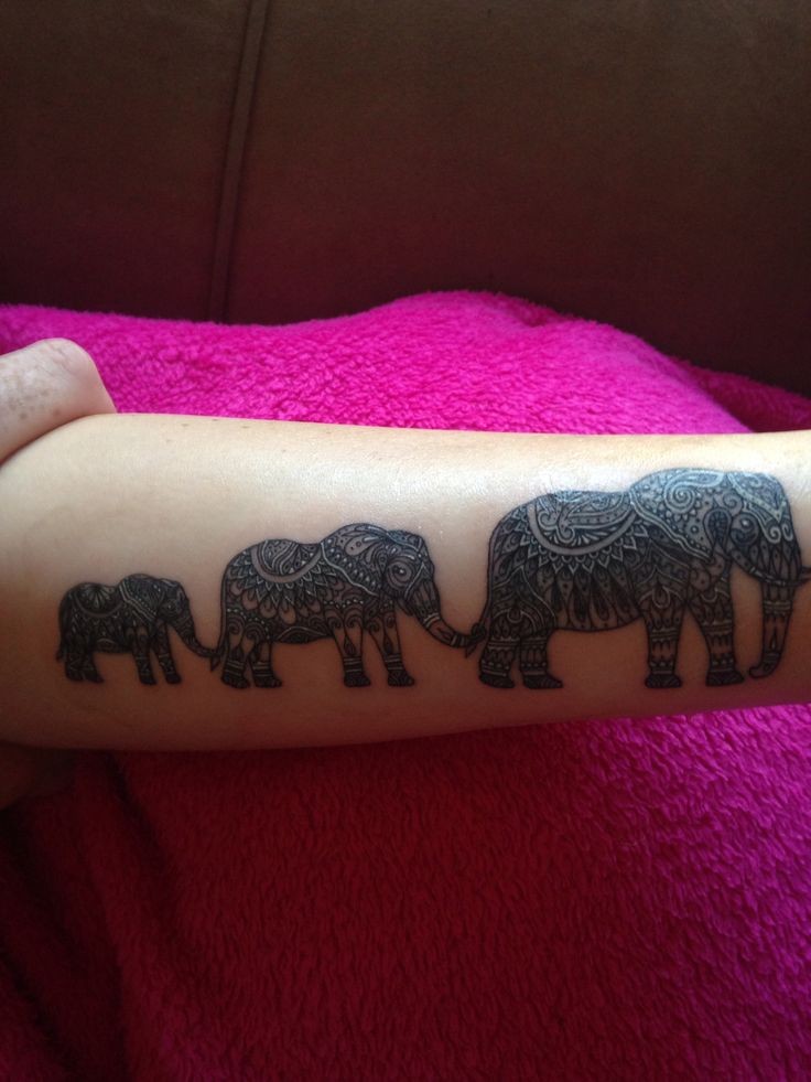 Wonderful great-ornamented elephant family hanging by tales tattoo on arm