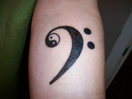 Tatuaje en el brazo, yin yang, signos de puntuación