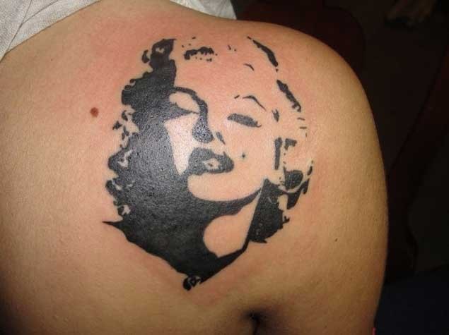 Abstract style black and white shoulder tattoo of Merlin Monroe portrait