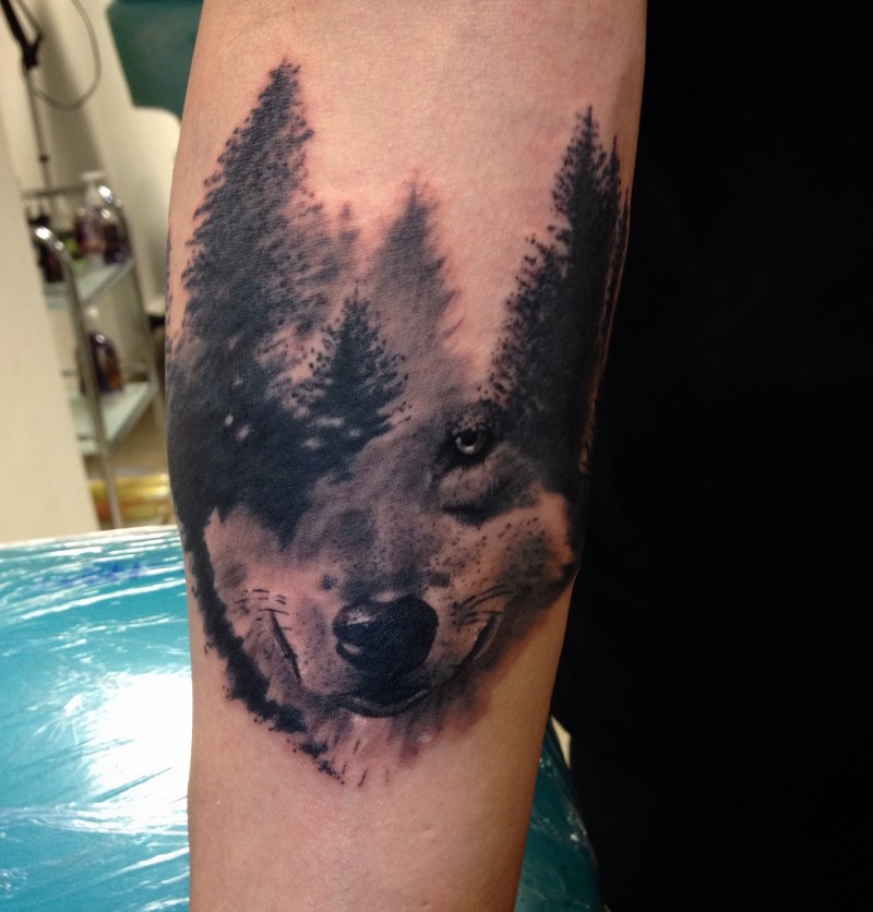 Abstract style black ink arm tattoo of deep forest with wolf