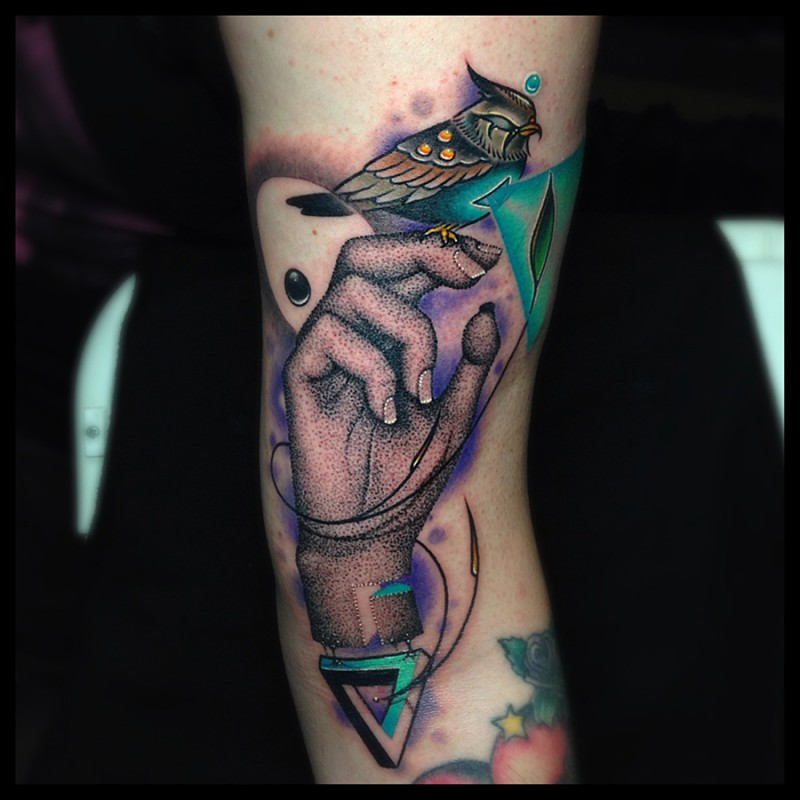 Abstract style colored arm tattoo of woman hand with bird and symbols