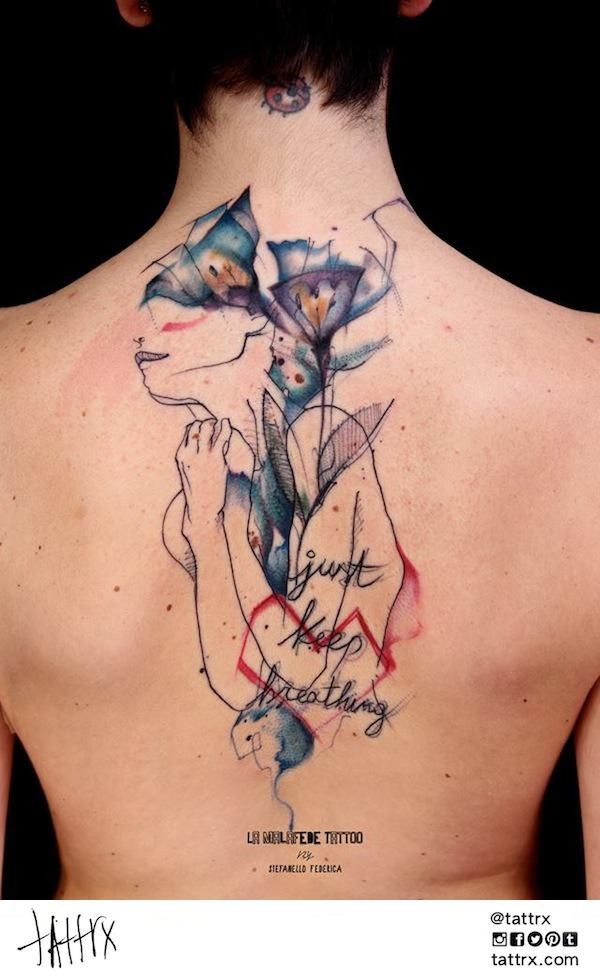 Abstract style colored back tattoo of woman like silhouette with flowers and lettering