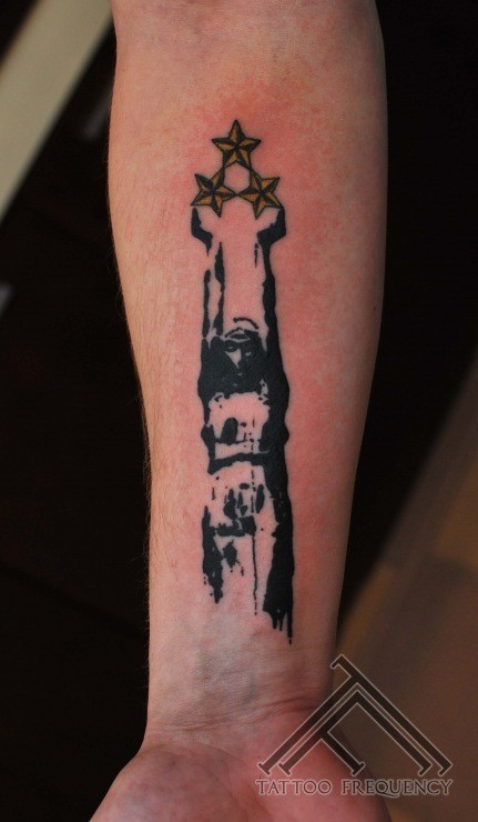 Abstract style colored forearm tattoo of big statue with stars
