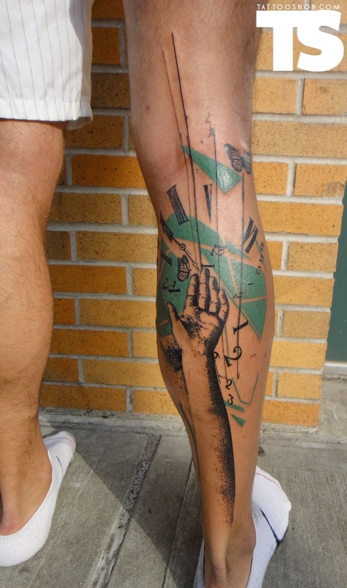 Abstract style colored leg tattoo of human hand with big clock