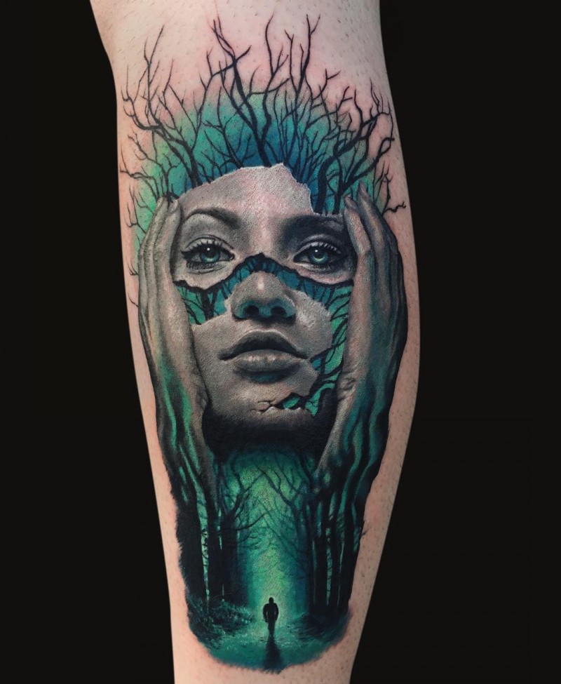 Abstract style colored leg tattoo of woman face with forest