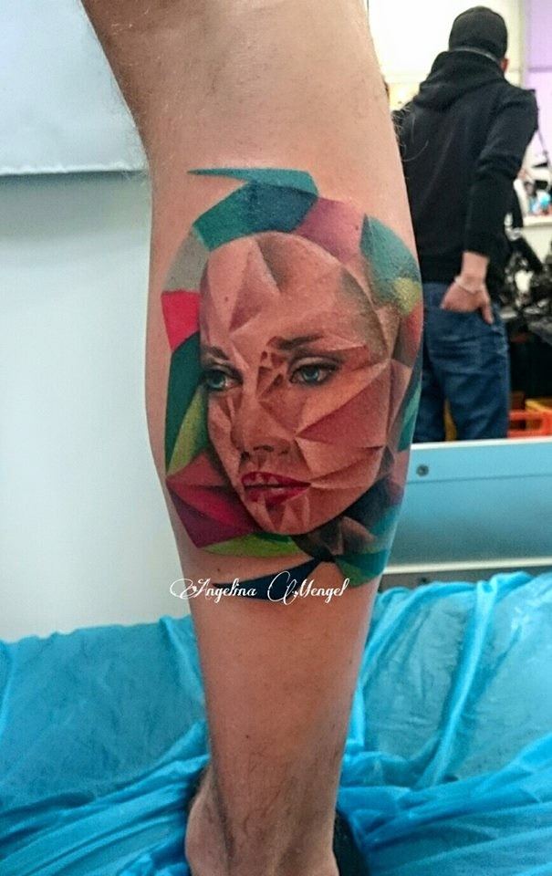 Abstract style colored leg tattoo of woman face