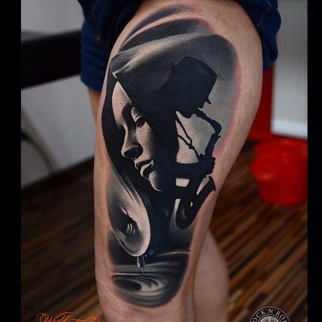 Abstract style colored thigh tattoo of woman with man and sax