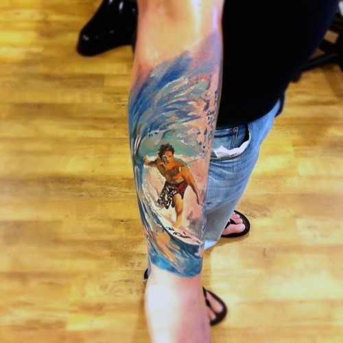 Abstract style colorful surfer in wave tattoo on arm