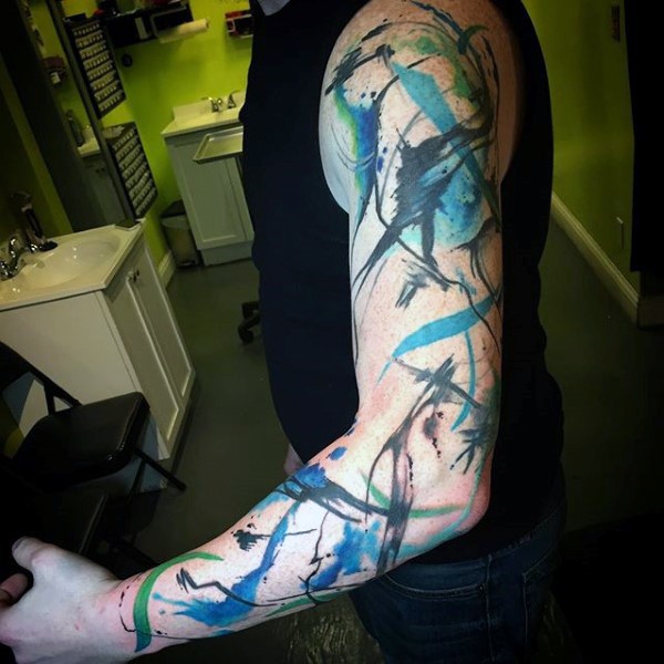 Tatuaje en estilo abstracto en el brazo complejo, colores negro azul