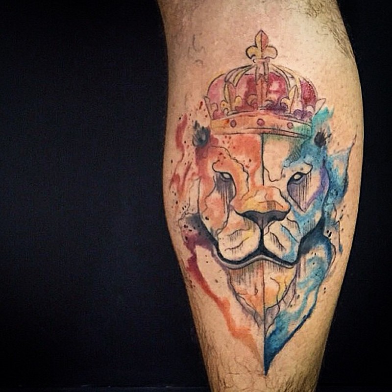 Abstract style multicolored lion face tattoo on leg stylized with crown