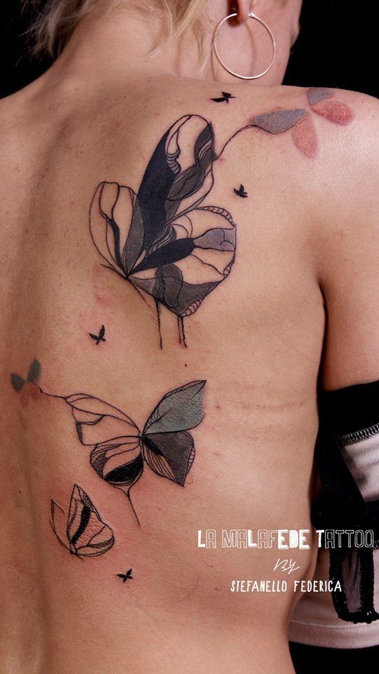 Abstract watercolor style big butterfly tattoo on back