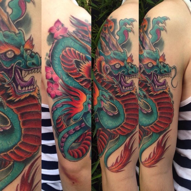 Accurate painted colored detailed fantasy dragon tattoo with pink flowers