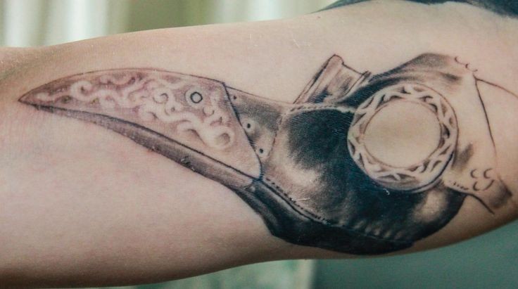 Accurate painted detailed biceps tattoo of plague doctors mask
