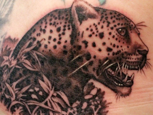 Adorable leopard in bushes tattoo