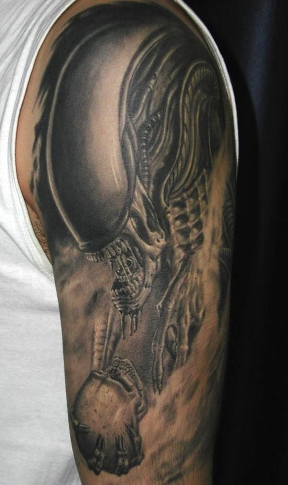 Tatuaje en el brazo,
monstruo de espacio extraterrestre con cráneo en la mano