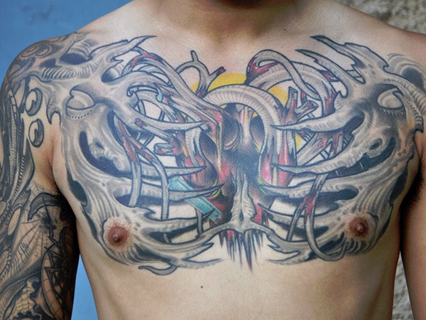 Alien style colored bones tattoo on chest with human heart