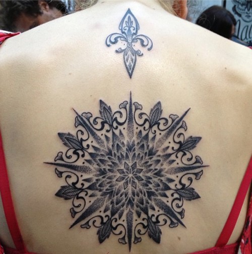 Tatuaje en la espalda, mandala grande y flor de lis pequeña