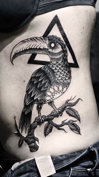 Amazing bird with black triangle tattoo on ribs by Daniel Meyer