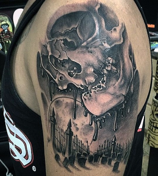 Amazing black and white corrupted human skull tattoo on shoulder combined with dark cemetery