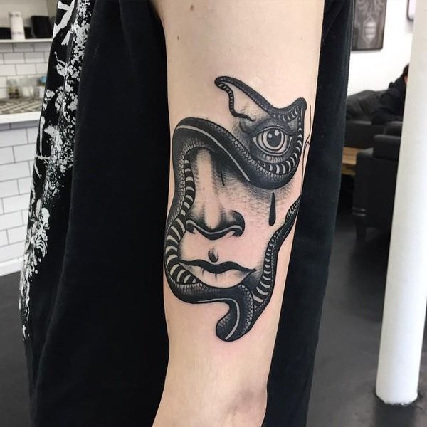 Tatuaje en el brazo,
retrato oscuro de mujer combinado con serpiente