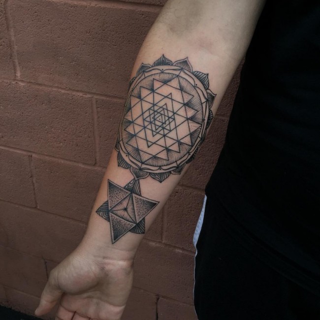 Amazing black ink ornamental flower tattoo on forearm with geometrical figure