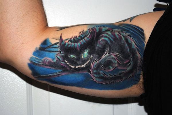 Amazing colored big fantasy cat tattoo on biceps
