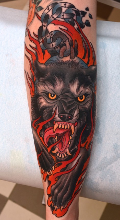 Tatuaje en el brazo, lobo demoniaco con cuernos y llamas