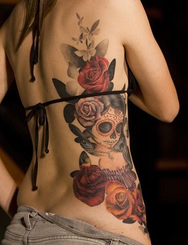 Tatuaje en las costillas,
santa muerte entre rosas