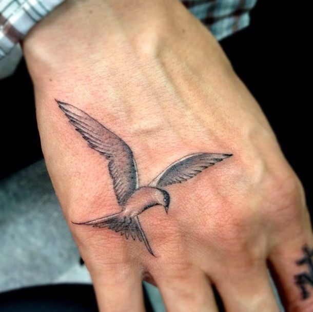 Tatuaje de ave tierna gris en la mano