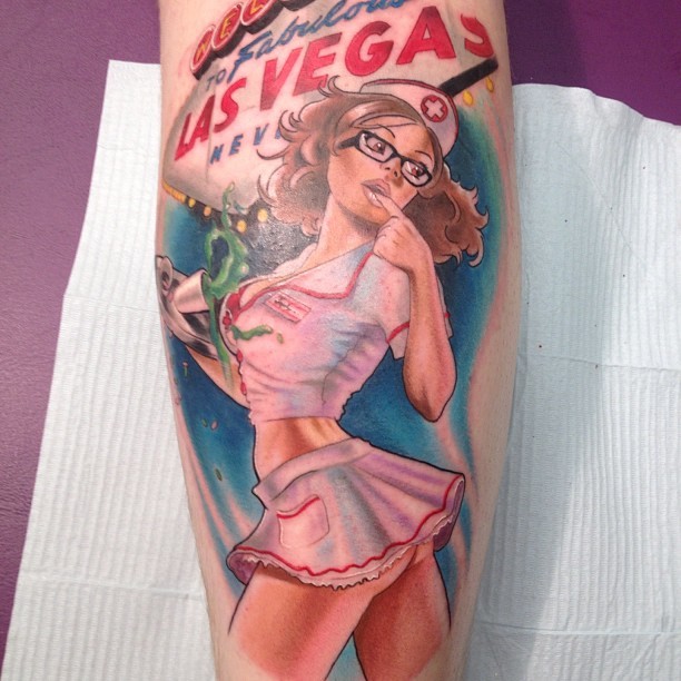 Amerikanische nette farbige sexy Krankenschwester mit Schriftzug Tattoo am Bein