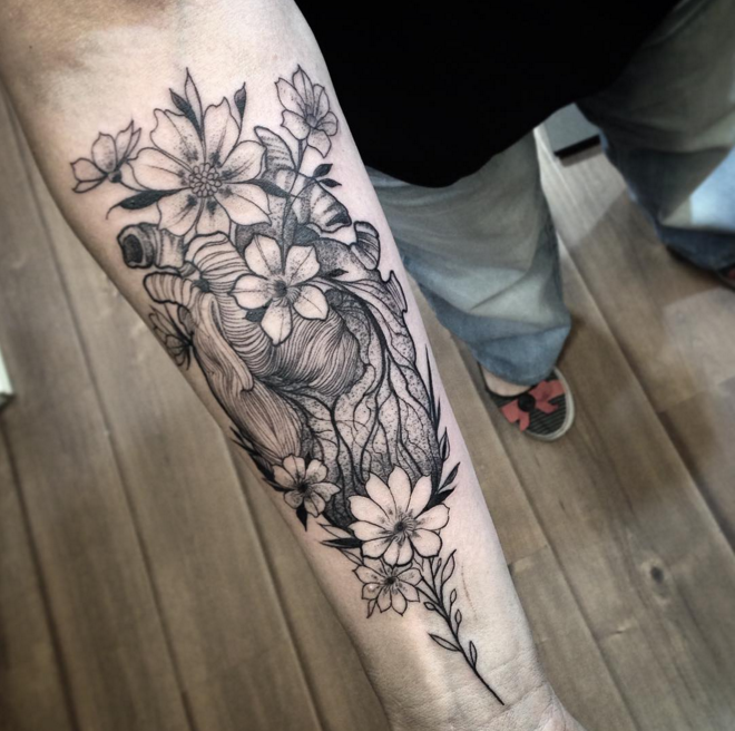 Anatomisches graues Herz mit Blumen Unterarmlänge Tattoo im Gravur surrealistischen Stil