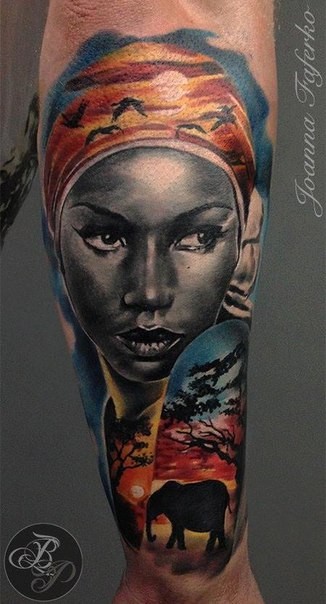 Ancient like colored arm tattoo of woman face stylized with trees and flying birds