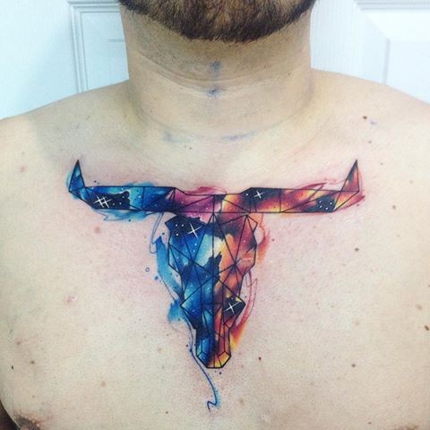 Animal horned skull tattoo on chest in abstract style with watercolor colored technique