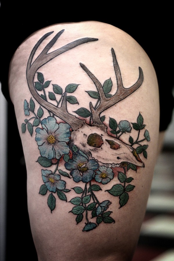 Art style colored thigh tattoo of animal skull with violet flowers