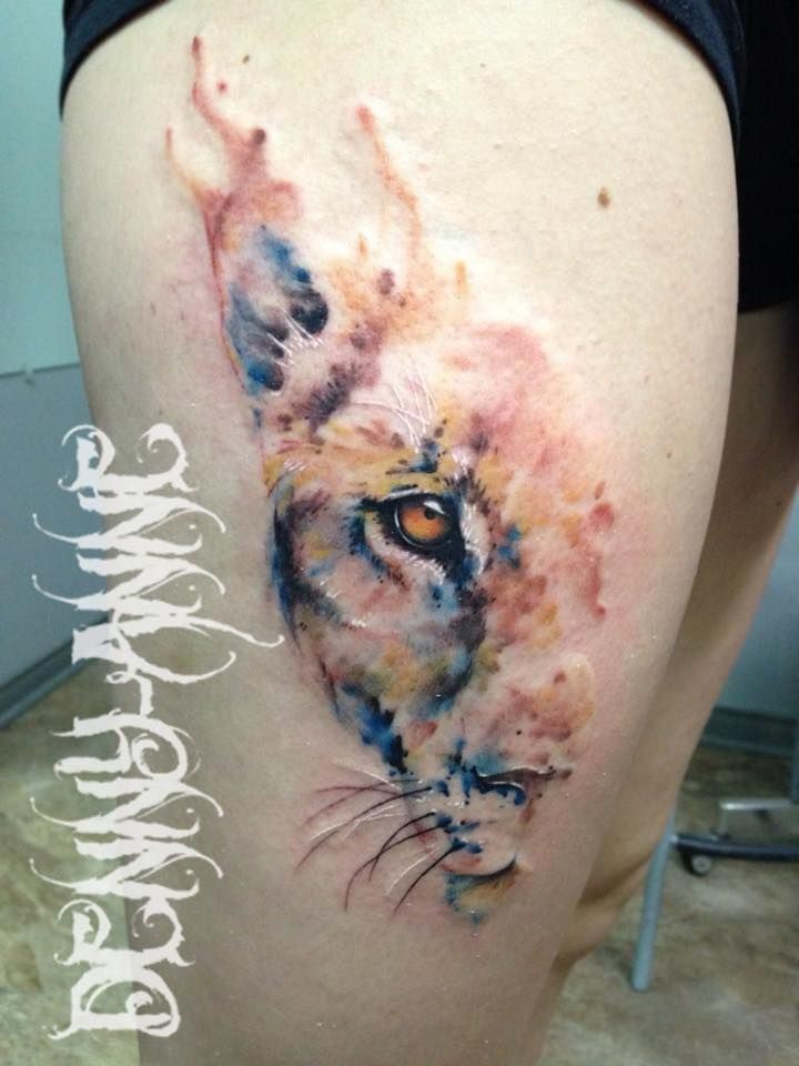 Art style colored thigh tattoo of lion head half