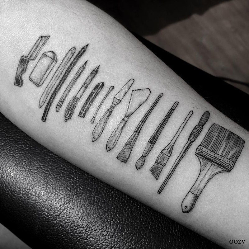 Artistic painting tools detailed forearm tattoo