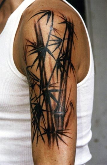 Asian bamboo tree detailed dark colored tattoo on upper arm