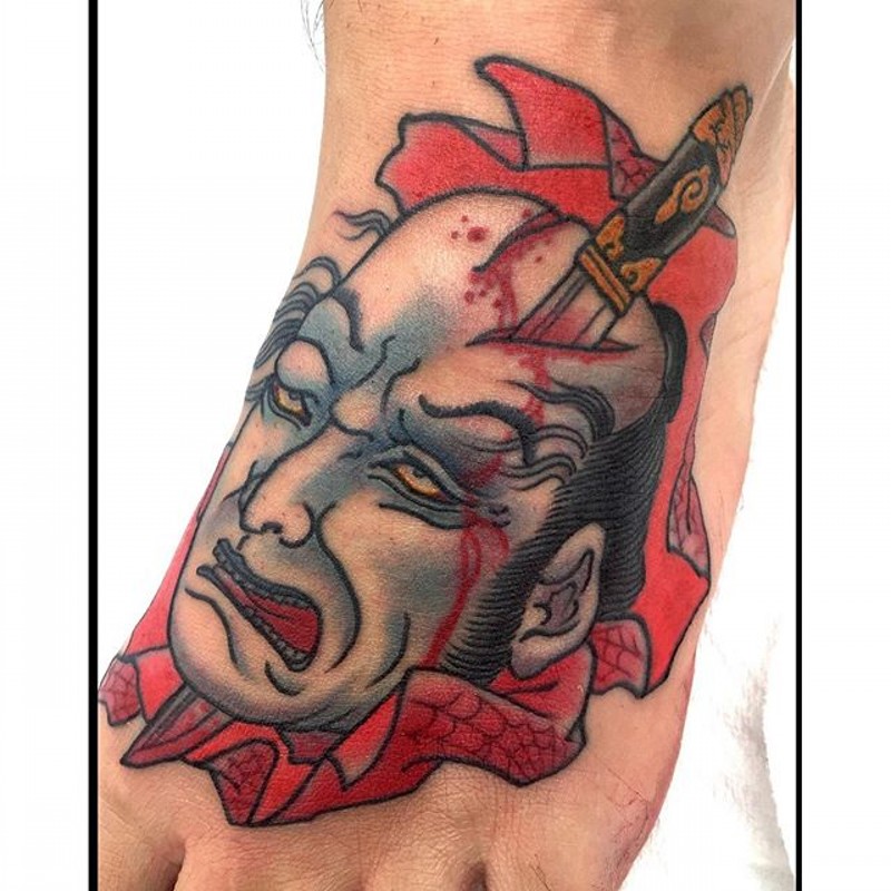 Asian native colored bloody foot tattoo of mans severed head