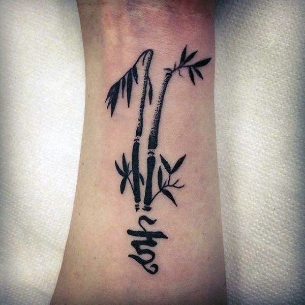 Asian oriental bamboo tree and hieroglyph symbol tattoo on forearm