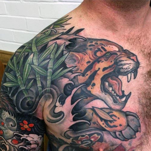 Asian oriental colored jumping furious tiger tattoo on arm and chest with bamboo and water waves