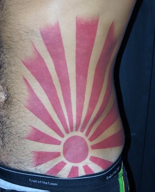 Asian oriental style red sun with long rays red ink tattoo on belly and side