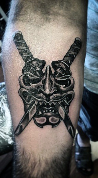 Asian style 3D like crossed swords with mask tattoo on arm