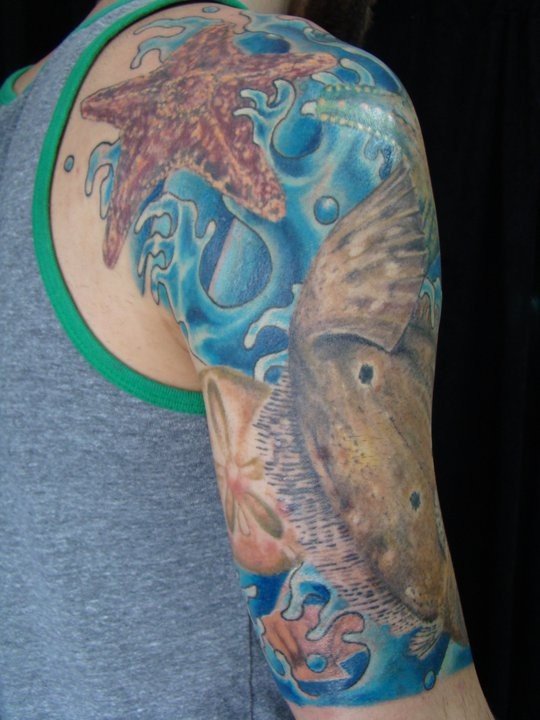 Tatuaje en el brazo, plantas submarinas y estrella de mar